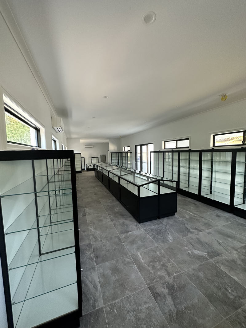 A long, elegant room fitted out with Showfront's custom memorabilia display cases for a client’s private collection.